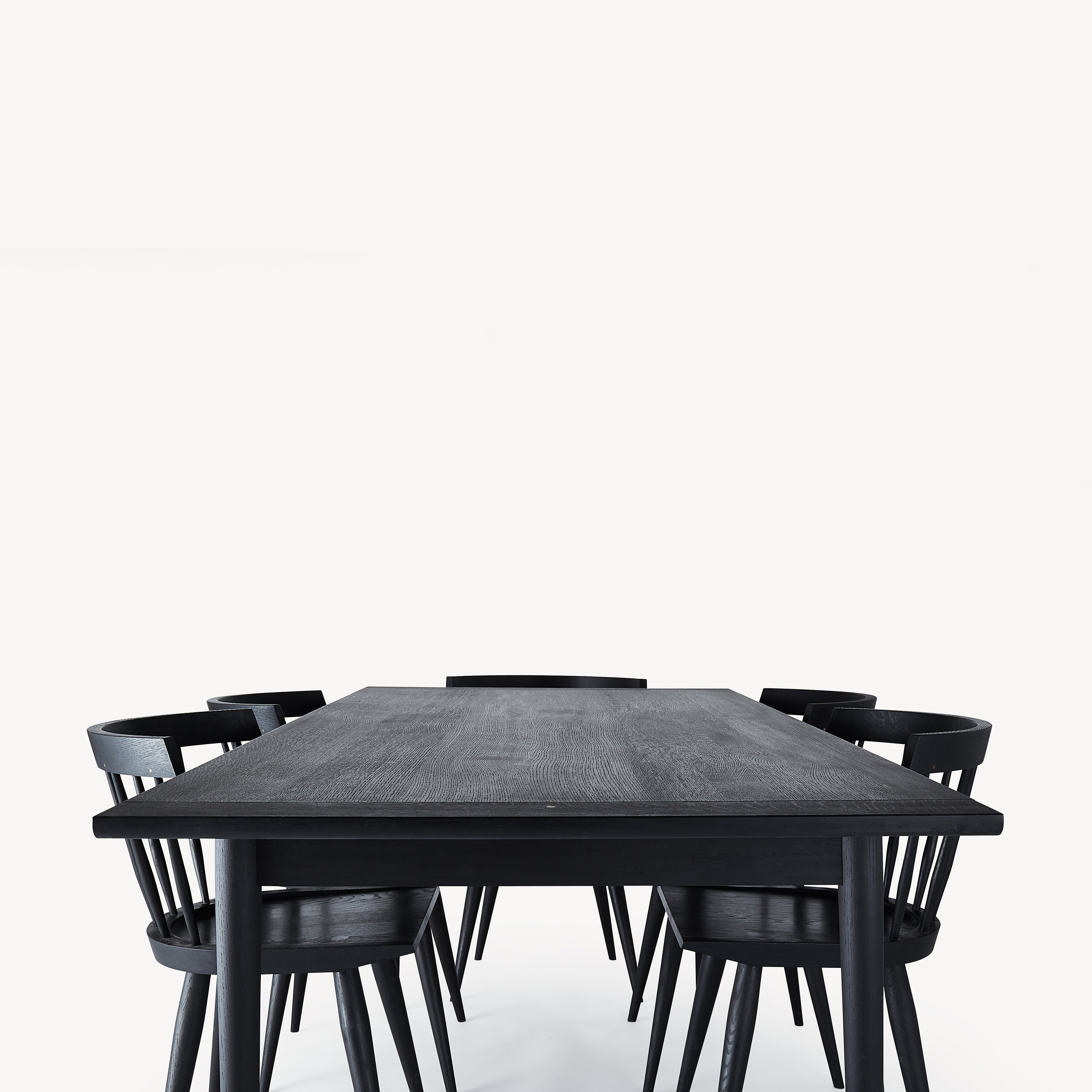black wooden dining table with five black wood chairs.