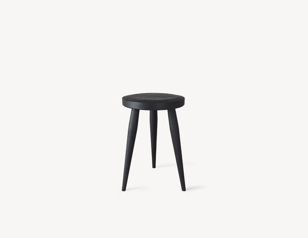 Three-legged milking stool with turned legs and a circular seat in dark stained wood