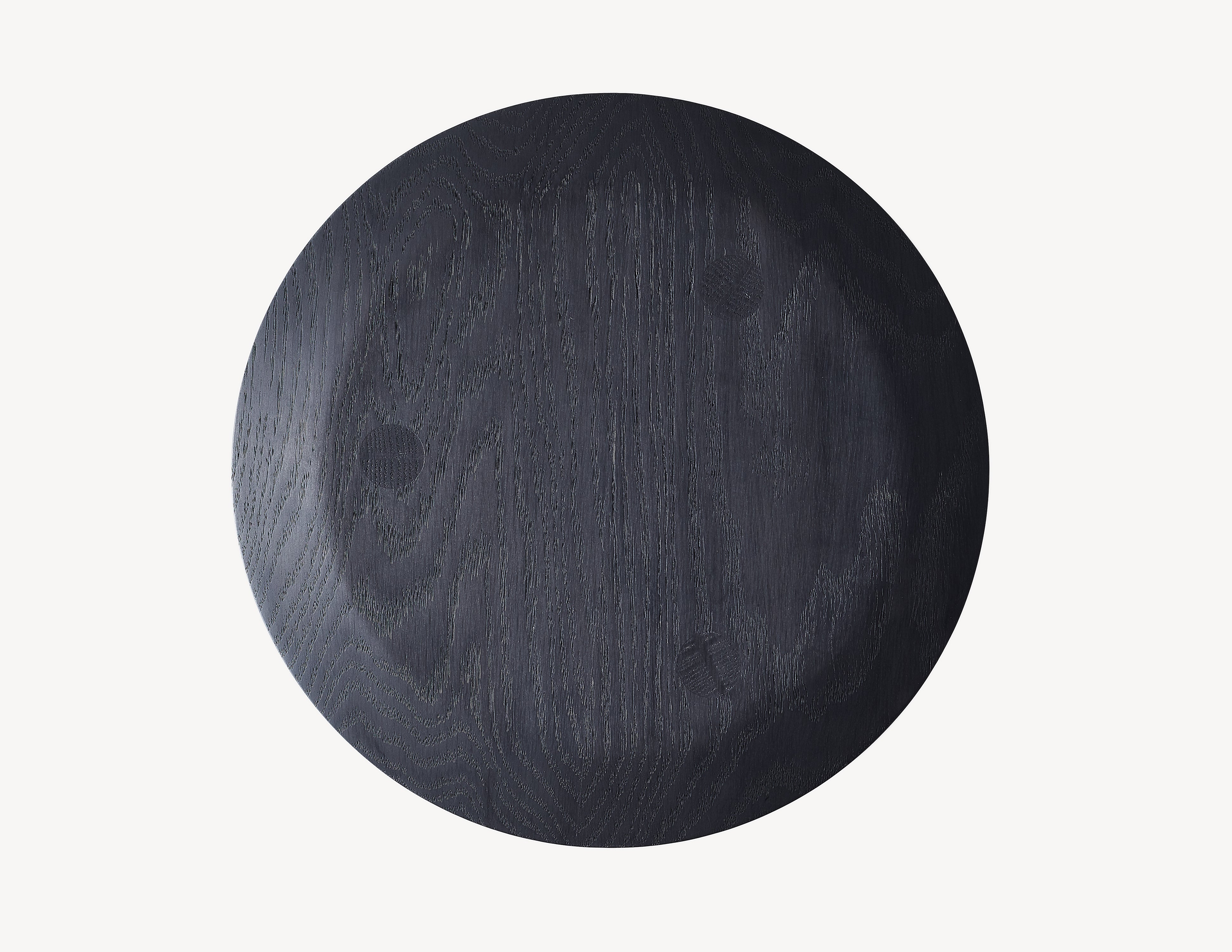 Top view of a three-legged black milking stool with turned legs and a circular seat in dark stained black wood
