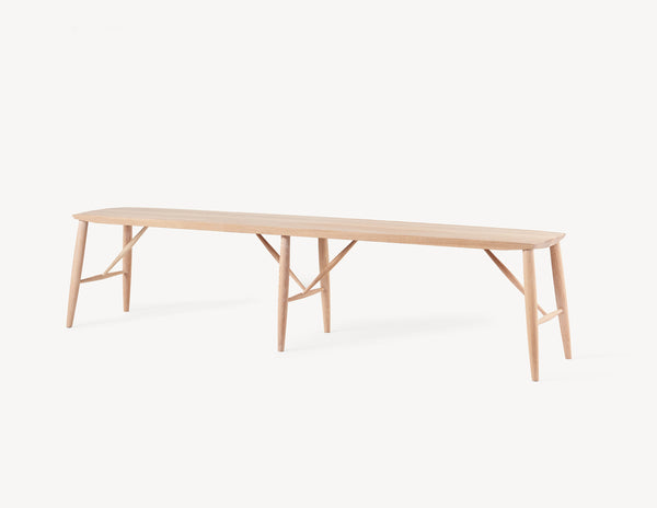 minimal wooden long oak bench in light wood.  three quarter view.
