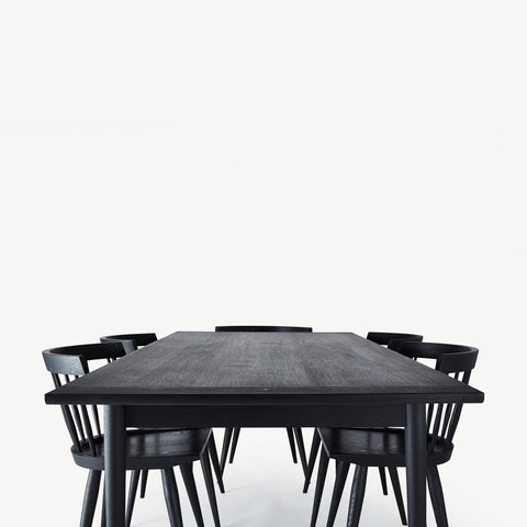 black wooden dining table with five black wood chairs. 