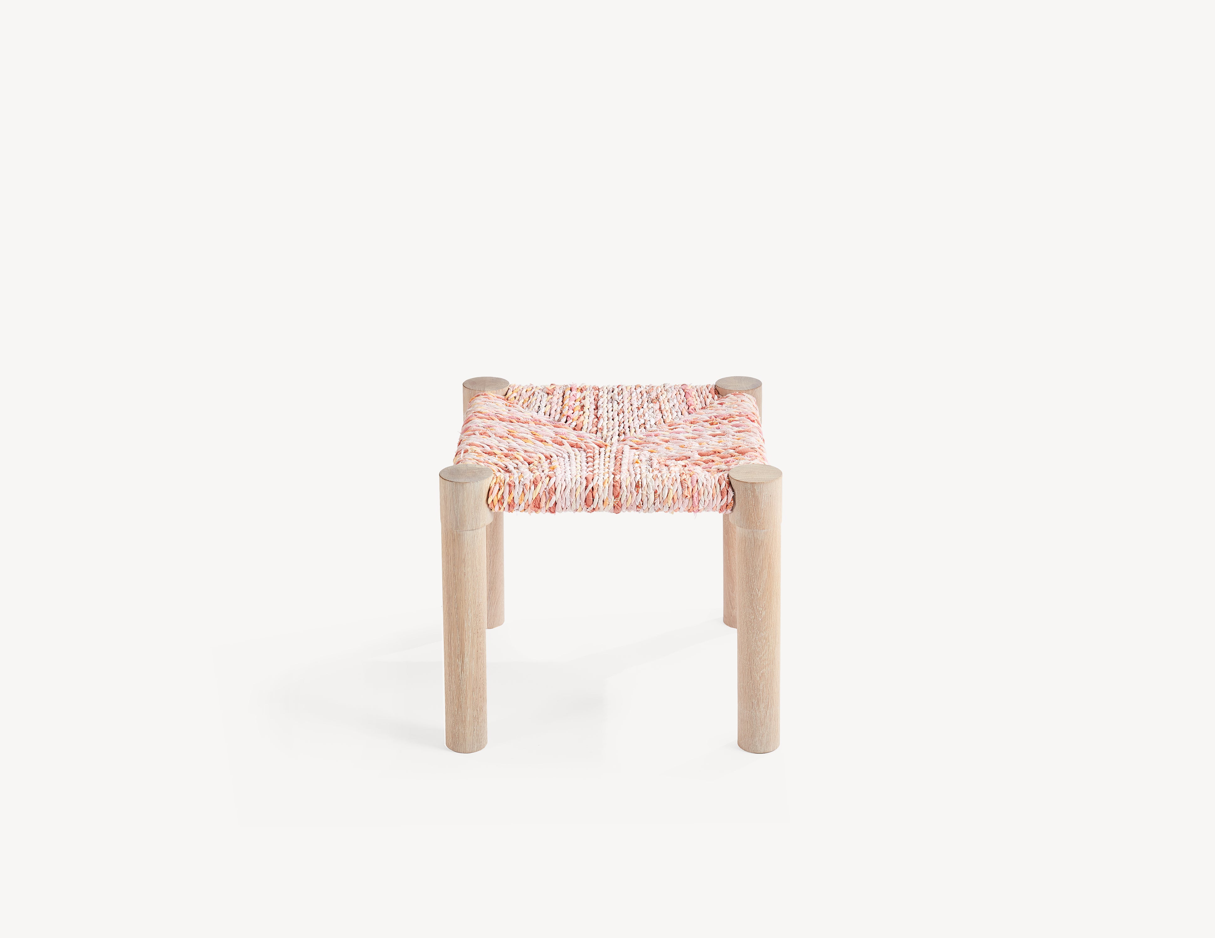wooden stool with pink woven seat.  high view.